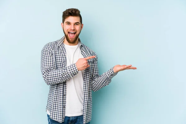 Young Caucasian Man Isolated Blue Background Excited Holding Copy Space — Stock Photo, Image