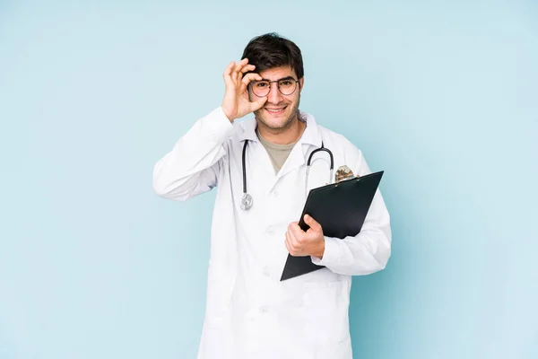 Jovem Médico Homem Isolado Fundo Azul Animado Mantendo Gesto Olho — Fotografia de Stock