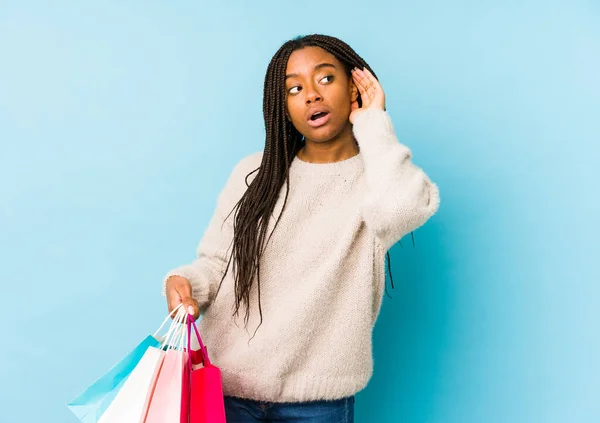Ung Afrikansk Amerikansk Kvinna Håller Shoppingpåse Isolerad Försöker Lyssna Ett — Stockfoto