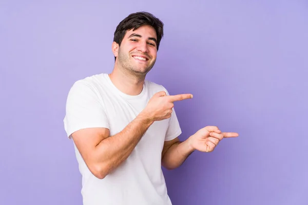 Jongeman Geïsoleerd Paarse Achtergrond Opgewonden Wijzend Met Wijsvingers Weg — Stockfoto