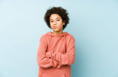 Afro-Amerikalı küçük çocuk, hoşnutsuzca somurtan yüzü izole edip kollarını kavuşturuyor..