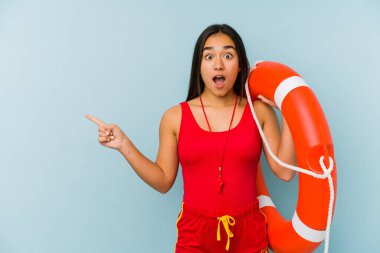 Asyalı genç bir cankurtaran yan tarafı işaret ediyor.