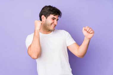 Mor arka planda yaşayan genç adam dans ediyor ve eğleniyor..