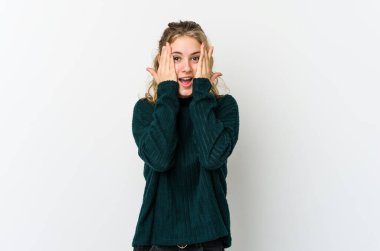 Beyaz sırtlı genç beyaz kadın yüzünün yarısını palmiye ile örterek eğleniyor..