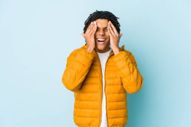 Genç melez adam yüzünün yarısını avuç içiyle örterek eğleniyor..