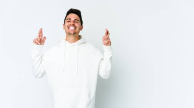 Beyaz arka planda izole genç beyaz adam şans dilemek için şans diliyor.