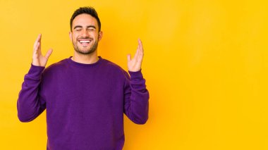 Kafkasyalı genç adam sarı fırında yapayalnız, neşeli bir şekilde gülüyor. Mutluluk kavramı.