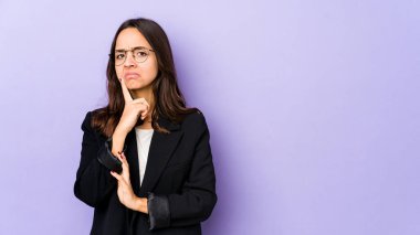 Latin kökenli genç bir kadın şüpheli ve şüpheci bir ifadeyle yanlamasına bakıyor..