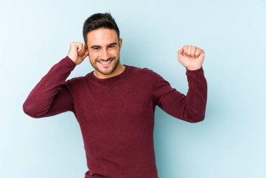 Genç beyaz adam mavi arka planda izole edilmiş dans ediyor ve eğleniyor..