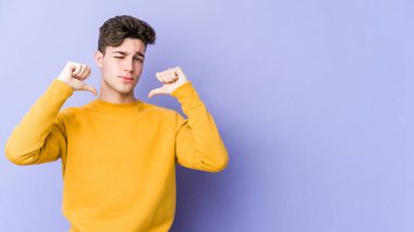 Mor arka planda izole edilmiş genç beyaz adam gururlu ve kendinden emin hissediyor, örnek olarak.