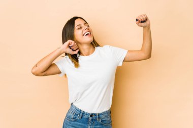 Bej arka planda yalnız kalmış genç bir kadın dans ediyor ve eğleniyor..