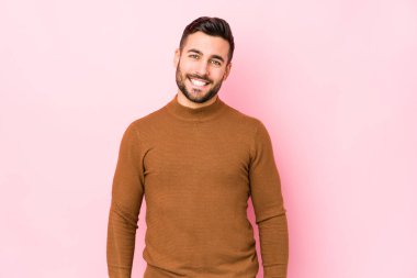 Pembe arka planda genç beyaz bir adam izole edilmiş, mutlu, güler yüzlü ve neşeli..