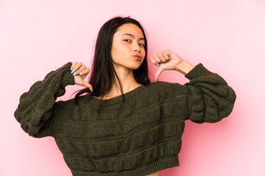 Pembe arka planda izole edilmiş genç Çinli kadın gururlu ve kendinden emin hissediyor, örnek olarak..