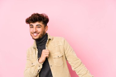 Genç Arap adam arka planda poz veriyor yalnız dans ediyor ve eğleniyor..