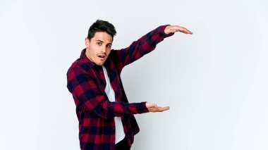 Beyaz arka planda izole edilmiş genç beyaz adam elleri arasında bir kopya alanı tutarken şok ve hayrete düştü..