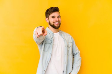 Sarı arka planda izole edilmiş genç beyaz adam öne bakan neşeli gülücükler.