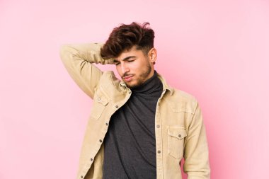 Arka planda poz veren genç bir Arap sabit yaşam tarzından dolayı boyun ağrısı çekiyor..