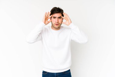 Beyaz arka planda izole genç bir adam hoş bir sürprizle karşılaşıyor, heyecanlı ve el kaldırıyor..