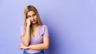 Mor arka planda soyutlanmış genç sarışın kadın üzgün ve dalgın hissediyor..