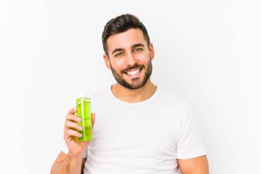 Genç, beyaz bir adam aloe vera ile nemlendirici tutuyor mutlu, güler yüzlü ve neşeli..