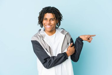 Genç Afro-Amerikan sporcusu işaret parmağıyla işaret ederek gülümsüyor..