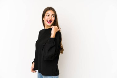 Beyaz arka planda izole genç beyaz kadın başparmak uzakta, gülüyor ve kaygısız.