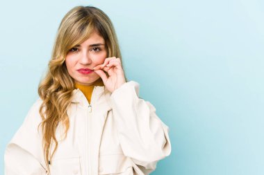 Genç, sarışın, beyaz, parmakları dudaklarında, sır saklayan kadın..