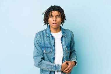 Kot ceket giyen genç siyahi adamın karaciğeri ağrıyor, karnı ağrıyor..