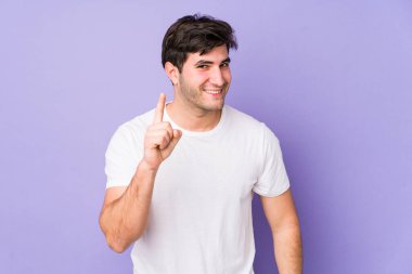 Mor arka planda izole genç bir adam parmak ile bir numara gösteriyor.