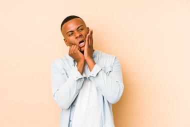 Genç latin adam bej arka planda izole edilmiş sızlanıyor ve ağlıyordu..