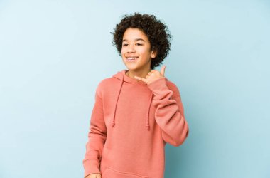 Afrika kökenli Amerikalı küçük bir çocuk izole edilmiş, parmaklarıyla bir cep telefonu hareketi gösteriyor..