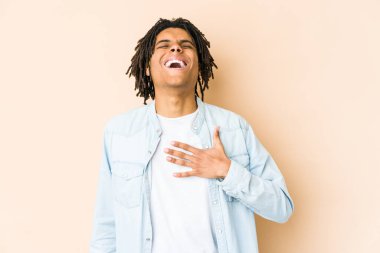 Genç Afrikalı Amerikalı Rasta adam elini göğsüne koyduğunda kahkahalar atıyor..