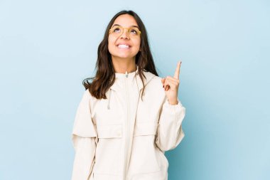 Genç, melez, Latin bir kadın. İki parmağı da boş bir alan gösteriyor..