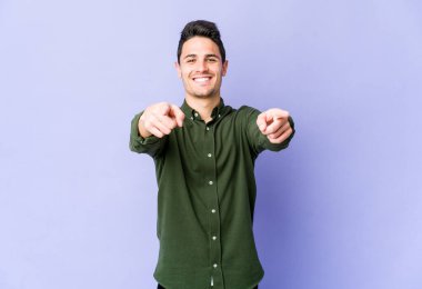 Mor arka planda izole edilmiş genç beyaz adam öne bakan neşeli gülücükler.