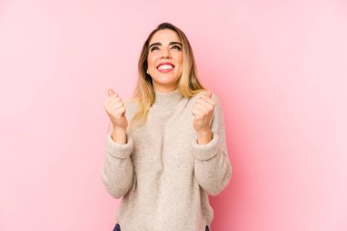 Orta yaşlı bir kadın izole olmuş, yumruğunu kaldırıyor, mutlu ve başarılı hissediyor. Zafer konsepti.