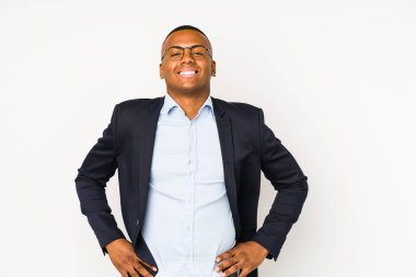 Genç iş adamı beyaz arka planda izole edilmiş, kendine güveni tam, kalçaları tutuyor..