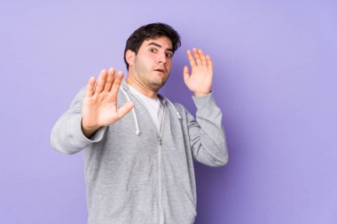 Mor arka planda izole genç bir adam yakın bir tehlike nedeniyle şoka uğruyor.