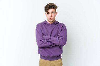 Beyaz arka planda izole olmuş beyaz tenli genç adamın yanakları şişer, yorgun bir ifadesi vardır. Yüz ifadesi kavramı.