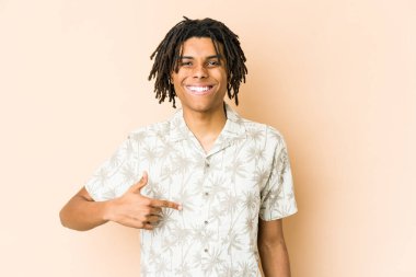 Afro-Amerikan Rasta 'lı genç bir adam gömleğin fotokopi odasını elle gösteriyor, gururlu ve kendinden emin.