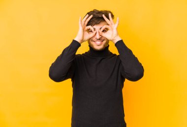 Sarı arka planda izole edilmiş genç bir Arap, gözlerde sorun olmadığını gösteriyor.