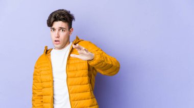 Mor arka planda izole genç beyaz adam yakın bir tehlike nedeniyle şoka uğruyor