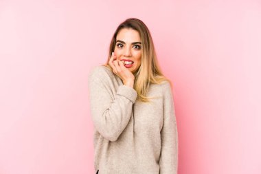 Soyutlanmış arka planda yaşayan, tırnak yiyen, gergin ve endişeli orta yaşlı bir kadın..