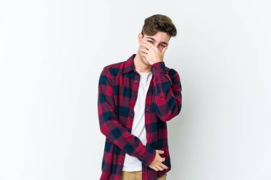 Beyaz arka planda izole olmuş genç beyaz bir adam gülüyor, kaygısız, doğal bir duygu..