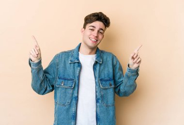 Beyazların arka planında izole edilmiş genç beyaz adam farklı kopya alanlarını gösteriyor, birini seçiyor, parmaklarıyla gösteriyor..