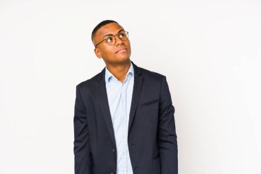 Genç iş adamı beyaz arka planda izole edilmiş hedeflere ve amaçlara ulaşma hayali kuruyor.