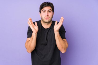 Mor arka planda izole genç adam şaşırdı ve şok oldu..