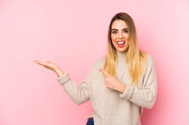 Orta yaşlı bir kadın, izole edilmiş arka planda heyecanlı bir şekilde elinde bir kopyasını tutuyor..