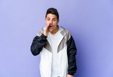 Mor arka planda izole edilmiş genç beyaz adam gizli bir sıcak fren haberi veriyor ve yana bakıyor.