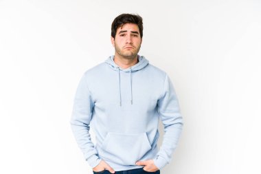 Beyaz arka planda soyutlanmış genç bir adam üzgün, ciddi bir yüz, sefil ve hoşnutsuz hissediyor..