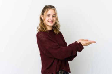 Beyaz arka plandaki genç beyaz kadın palmiye ağacında bir kopya alanı tutuyor..